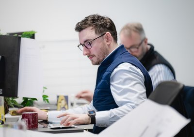 employee looking at drawings and computer screen